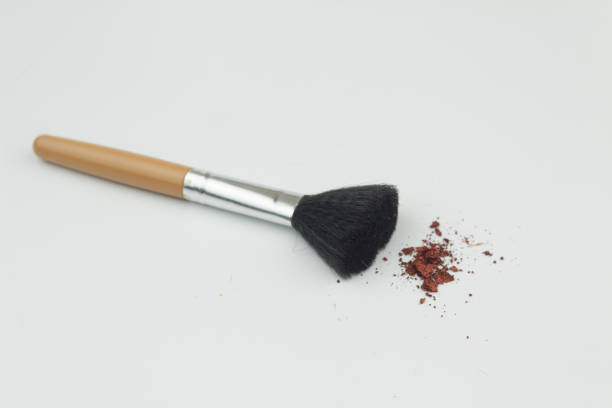 istock Make up brush with red cosmetic powder on isolated white background 971857260