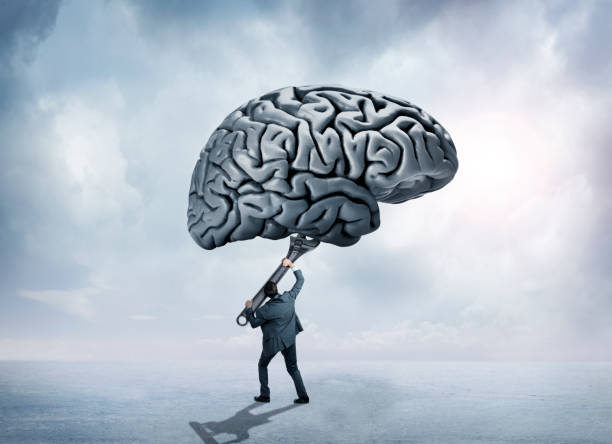 istock Man Uses Large Wrench To Adjust Brain Above Him 971858824