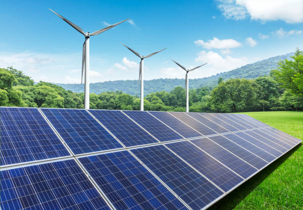 Solar panels and wind turbines in green field stock photo