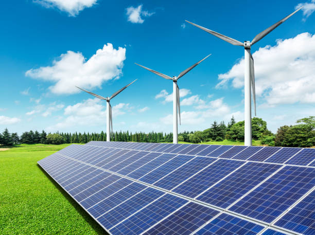 istock Solar panels and wind turbines in green field 971884902