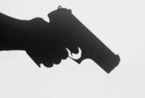 istock A shadow of a pistol being held 971885034