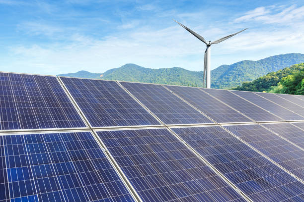 istock Solar panels and wind turbines with mountains landscape 971887432