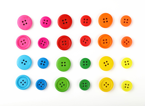 A collection of colorful plastic buttons backlit on a lightbox.