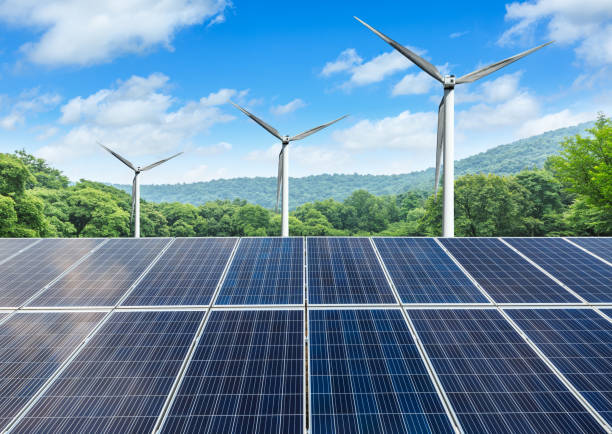 istock Solar panels and wind turbines with mountains landscape 971896116