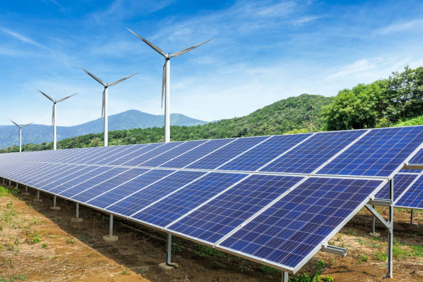 istock Solar panels and wind turbines with mountains landscape 971898258