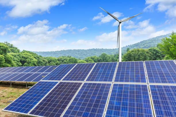 istock Solar panels and wind turbines with mountains landscape 971898766