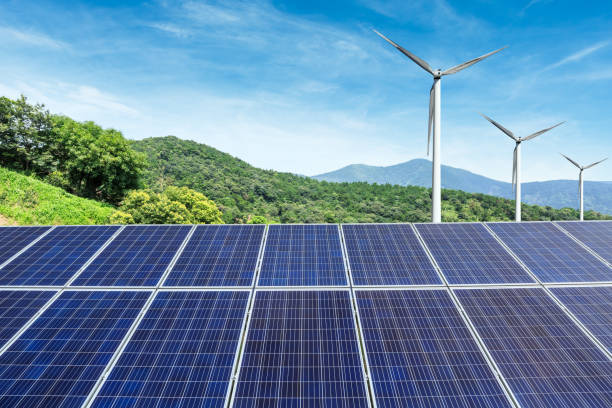 istock Solar panels and wind turbines with mountains landscape 971899044