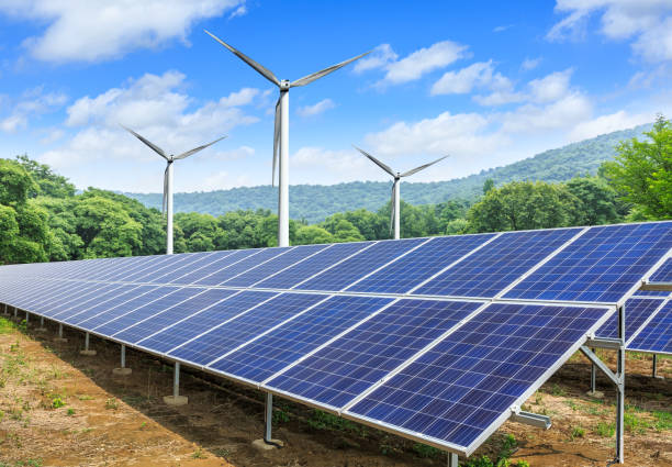 istock Solar panels and wind turbines with mountains landscape 971899046