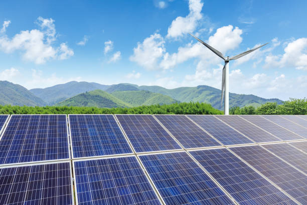 istock Solar panels and wind turbines with mountains landscape 971899164