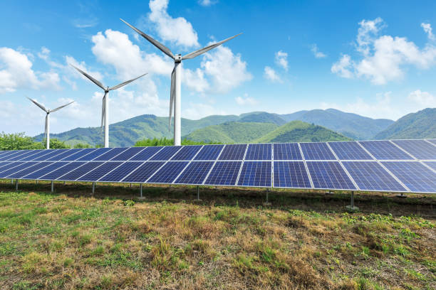 istock Solar panels and wind turbines with mountains landscape 971899166