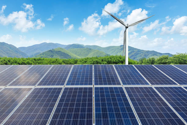 istock Solar panels and wind turbines with mountains landscape 971903474
