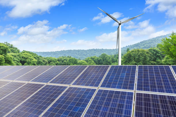 istock Solar panels and wind turbines with mountains landscape 971903652