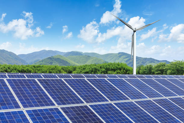 istock Solar panels and wind turbines with mountains landscape 971903826