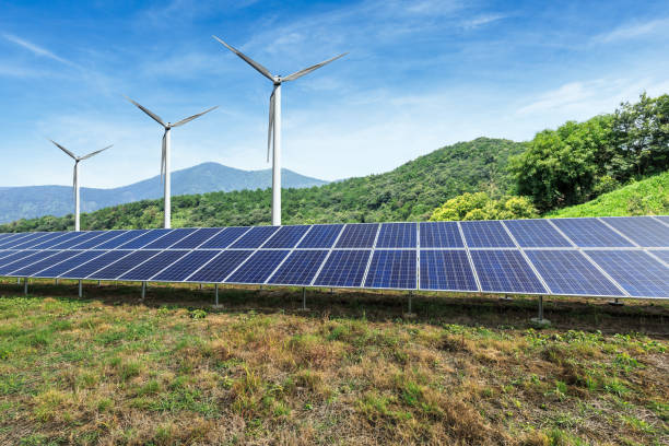 istock Solar panels and wind turbines with mountains landscape 971903906