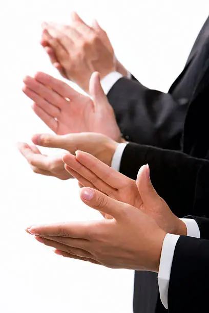 Photo of Close-up on the hands clapping of 3 formally dressed people