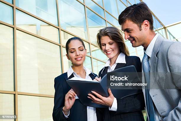 Three Business People Reviewing A Business Agreement Stock Photo - Download Image Now
