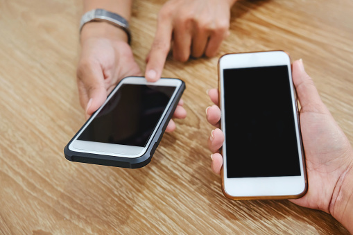 Two young women playing smartphone at restaurant