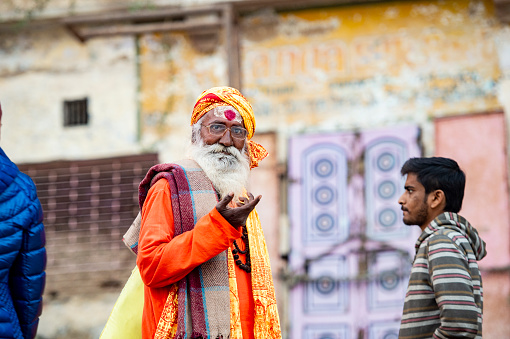 VARANASI - INDIA - 13 NOVEMBER 2017. A Sadhu is posing for a photo on the Ghat in Varanasi, India. Shadu is a religious ascetic, mendicant (monk) or any holy person in Hinduism and Jainism who has renounced the worldly life.
