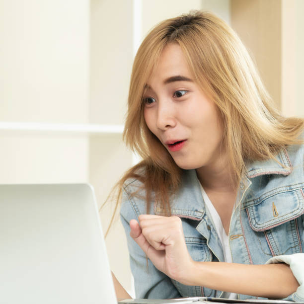 istock Cute woman feels excited while looking at computer 971942864