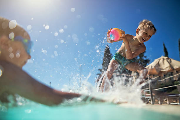 istock Little boys playing in resort swimming pool 971945728