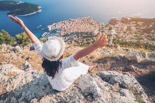 Traveller looking at view of Dubrovnik city, in Dalmatia, Croatia, the prominent travel destination of Croatia. Dubrovnik old town was listed as UNESCO World Heritage Sites in 1979.