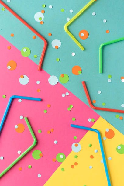 istock Vibrant confetti and straws on vivid background 971955864