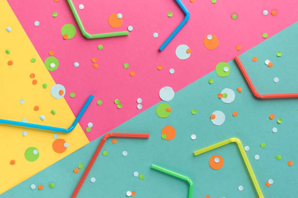 istock Vibrant confetti and straws on vivid background 971955890