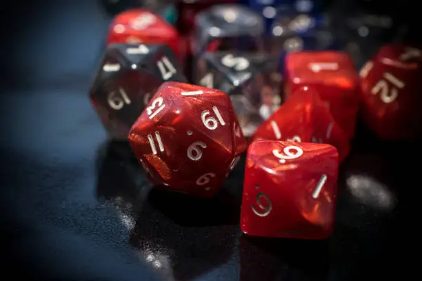 A set of red and transparent RPG dice on a black table