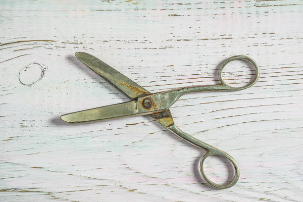 istock Old scissors on white paint old wooden background 971964302