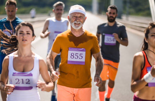 istock Smiling senior man participating in marathon race on the road. 971969896
