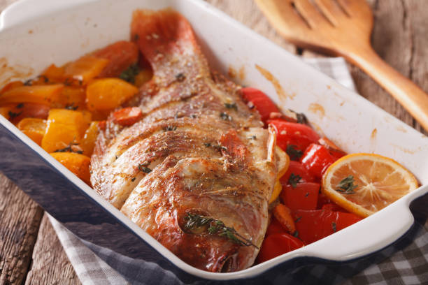 istock Tilapia baked with vegetables and thyme close up in baking dish. horizontal 971986348
