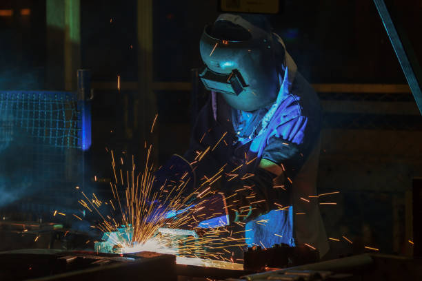 istock Industrial worker is welding steel with protective mask 971989626