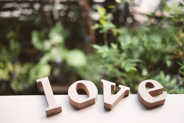 木製の文字は「love」と木製の床に赤いギフトボックスを語ります。自然の庭でのテキストを愛する。バレンタインデーとヴィンテージスタイルのコンセプトの背景に使用します。木製のアル - text wood alphabet nature ストックフォトと画像