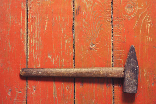 istock Old hammer on an old brown wooden background. 971998150