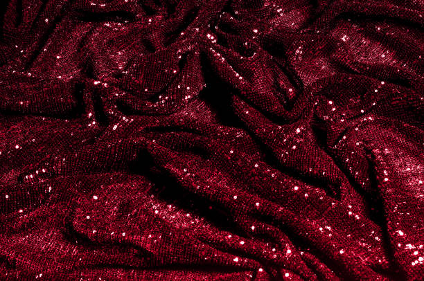 istock Texture, background, pattern, red fabric with paillettes. Look at these neon red sequins. Round neon pink sparkles glitter overlapping iridescent glitter on a clean purple grid. 971998526