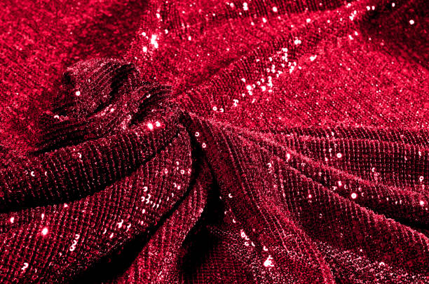 istock Texture, background, pattern, red fabric with paillettes. Look at these neon red sequins. Round neon pink sparkles glitter overlapping iridescent glitter on a clean purple grid. 971998550