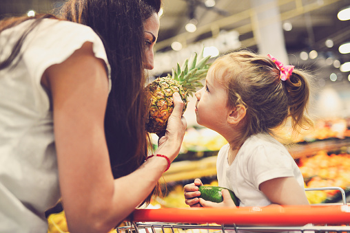 Mother and daughter buying fruit together