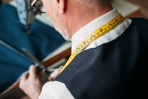istock cropped image of senior tailor cutting dark cloth at sewing workshop 972010116
