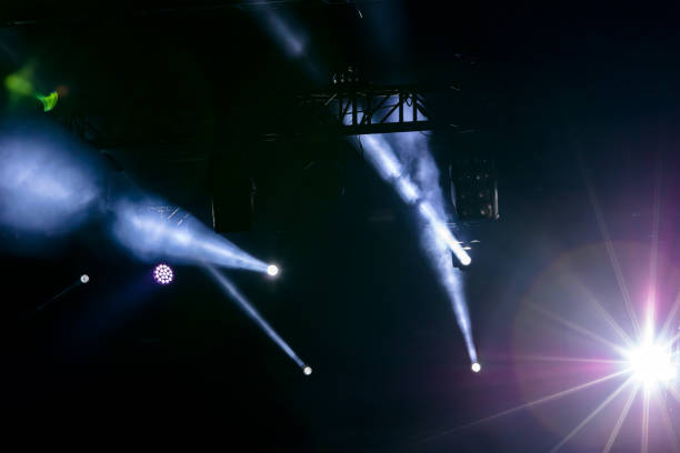 istock lights of projector equipment over dark stage 972012870