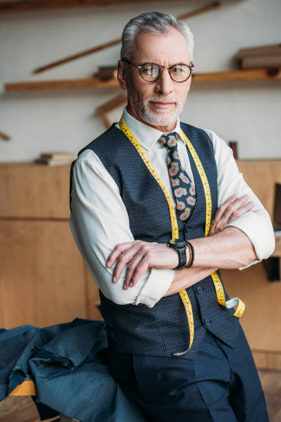 istock handsome tailor standing with crossed arms at sewing workshop 972016150