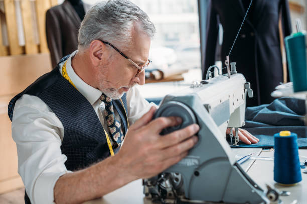istock side view of senior tailor sewing cloth with sewing machine at sewing workshop 972016474