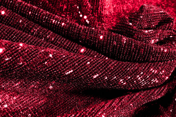 istock Texture, background, pattern, red fabric with paillettes. Look at these neon red sequins. Round neon pink sparkles glitter overlapping iridescent glitter on a clean purple grid. 972019984