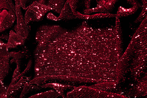 istock Texture, background, pattern, red fabric with paillettes. Look at these neon red sequins. Round neon pink sparkles glitter overlapping iridescent glitter on a clean purple grid. 972020038