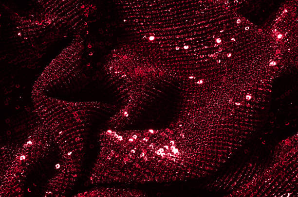 istock Texture, background, pattern, red fabric with paillettes. Look at these neon red sequins. Round neon pink sparkles glitter overlapping iridescent glitter on a clean purple grid. 972020148