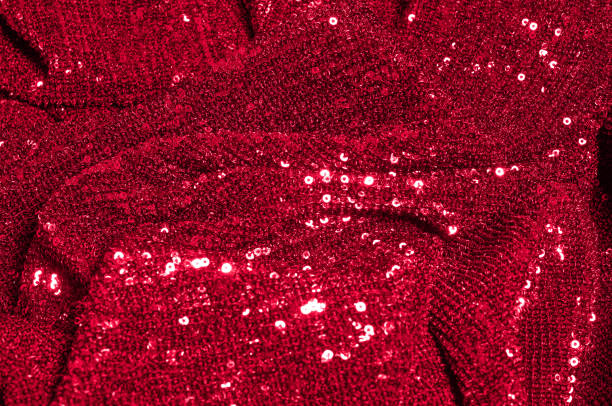 istock Texture, background, pattern, red fabric with paillettes. Look at these neon red sequins. Round neon pink sparkles glitter overlapping iridescent glitter on a clean purple grid. 972020172
