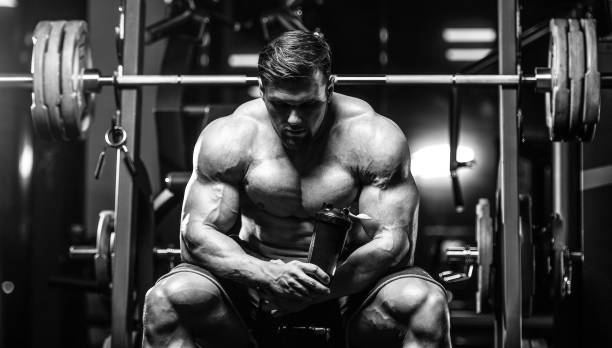 istock Brutal strong bodybuilder athletic men pumping up muscles with dumbbells 972020914