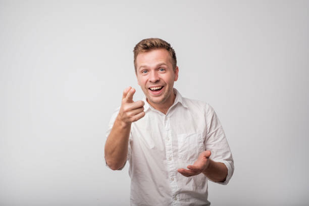 Young european man, laughing, pointing with finger at someone, something, isolated on white background. Young european man, laughing, pointing with finger at someone, something, isolated on white background. Positive human face expression. Studio shoot child laughing hysterically stock pictures, royalty-free photos & images