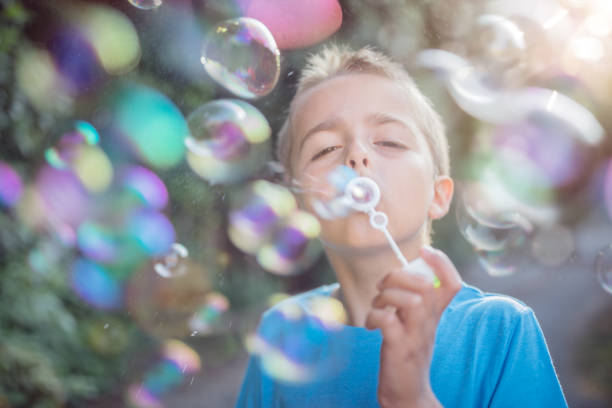 istock Blowing soap bubbles in the summer sun 972029106