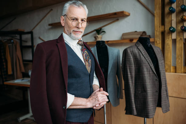 istock handsome mature tailor in stylish clothes at sewing workshop 972029504