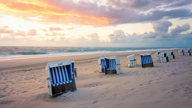 beach chairs, ocean and sunset beach chairs on the beach of sylt hooded beach chair stock pictures, royalty-free photos & images